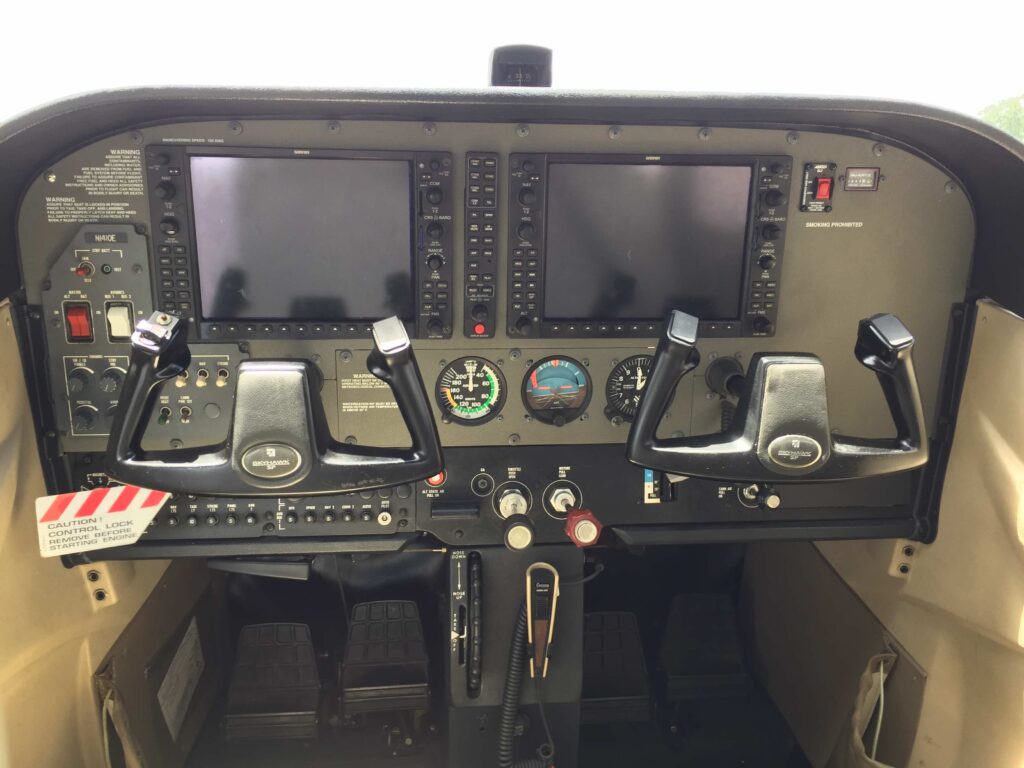Modern glass cockpit of a Cessna Skyhawk SP featuring dual G1000 digital displays and dual control yokes.